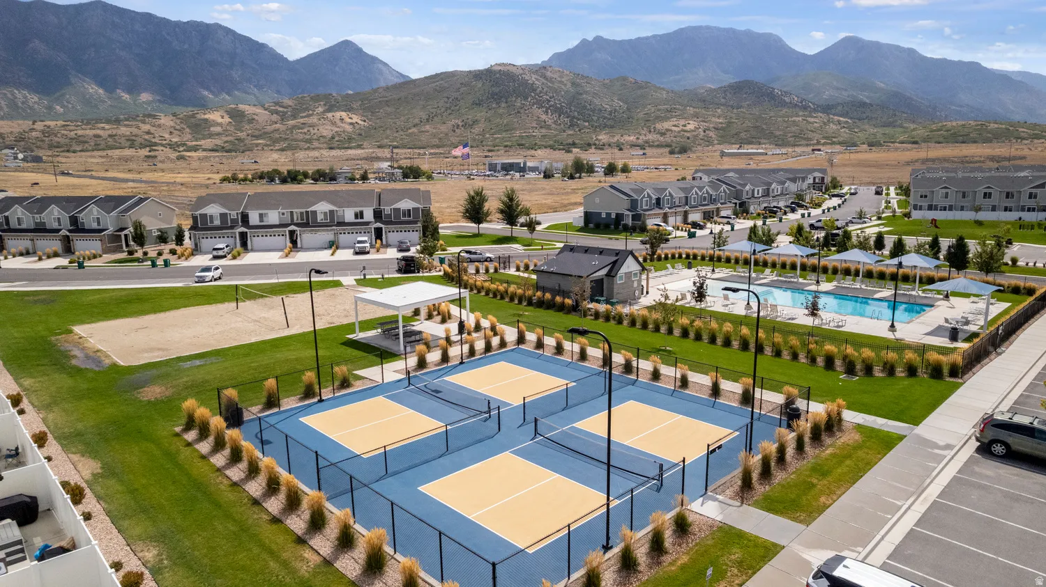 Multiple pickleball courts, a sand volleyball court, a swimming pool, and a community building