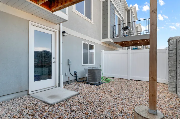 Full Daylight Walkout basement and fully fenced backyard,Gravel hardscaping, full-light exterior door, exterior wall sconce, private vinyl fencing, and a permanent wood beam. Perfect for pets.