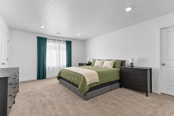 Wall-to-wall carpeting, recessed ceiling lighting, and a window with blinds