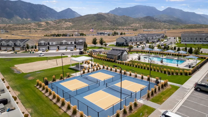 Multiple pickleball courts, a sand volleyball court, a swimming pool, and a community building