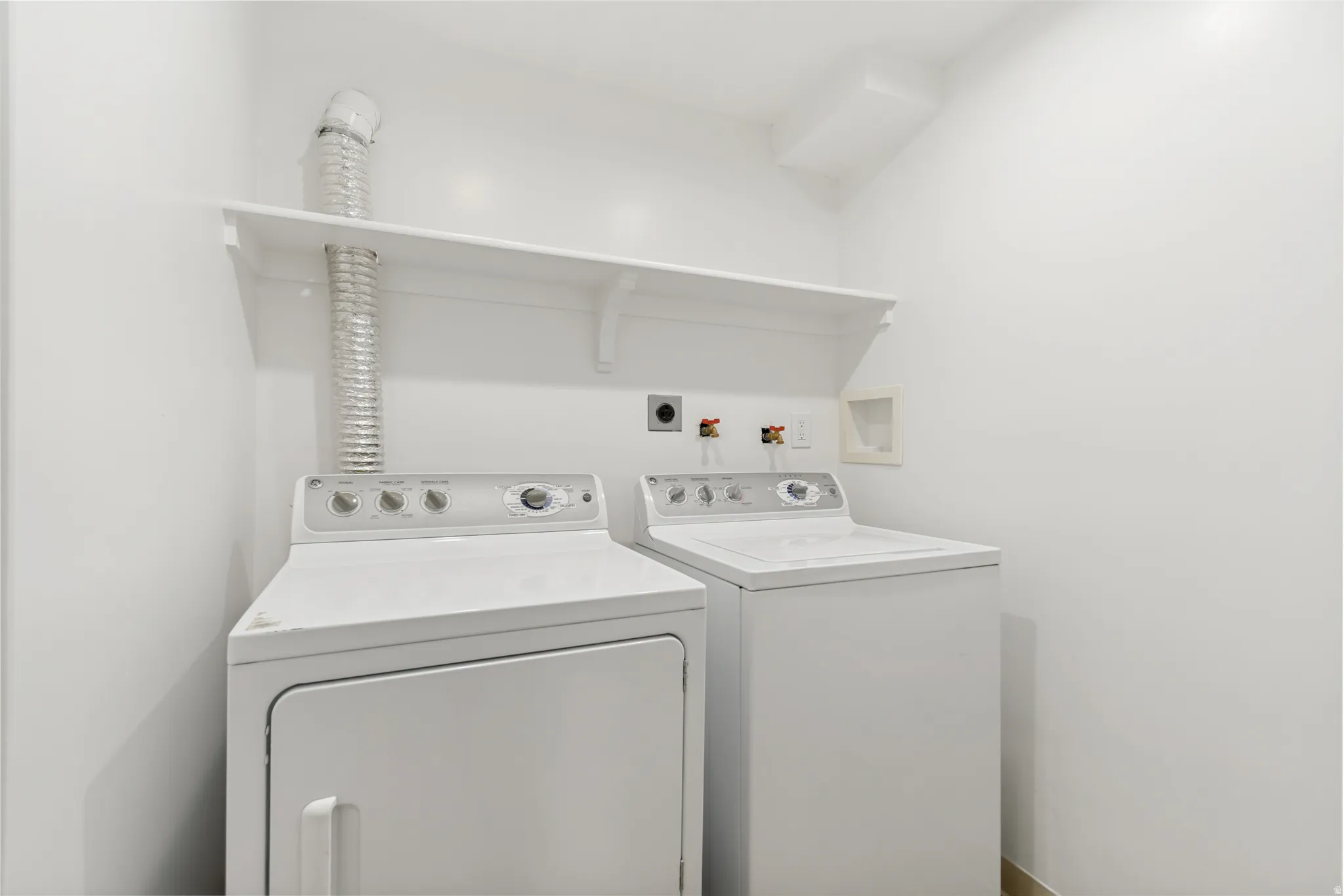 Laundry area with wall-mounted shelving