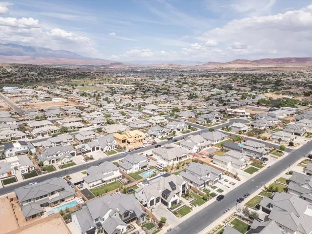 Residential neighborhood with paved streets and mature landscaping, featuring a mix of single-story and two-story homes