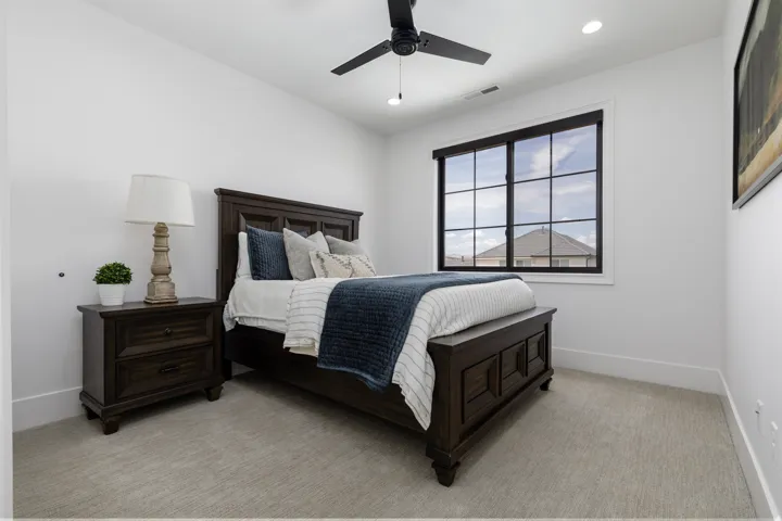 Carpeted room featuring a ceiling fan with light, recessed lighting, and a multi-pane window with dark trim