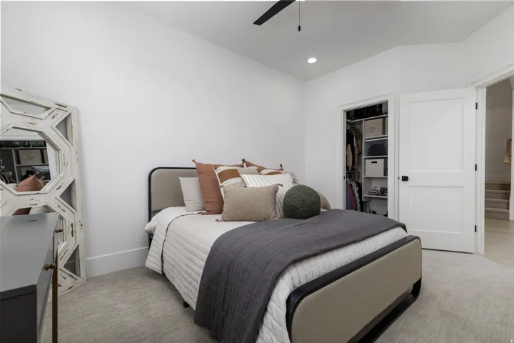 Recessed lighting, a ceiling fan, and a built-in closet with shelving