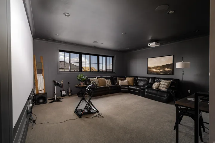Recessed ceiling lighting, large projector screen, mounted ceiling projector, and expansive window with dark trim