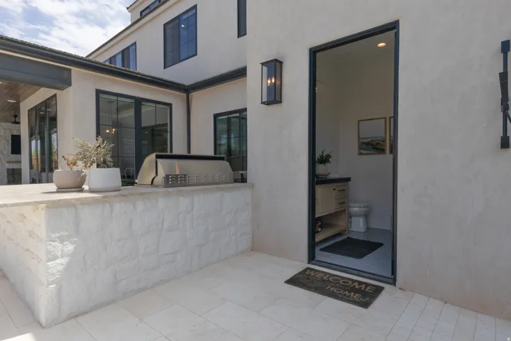 Outdoor kitchen with built-in grill and stone-clad base