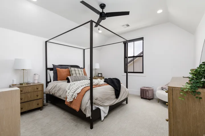 Vaulted ceiling with recessed lighting, ceiling fan, carpeted flooring, and a window with dark trim