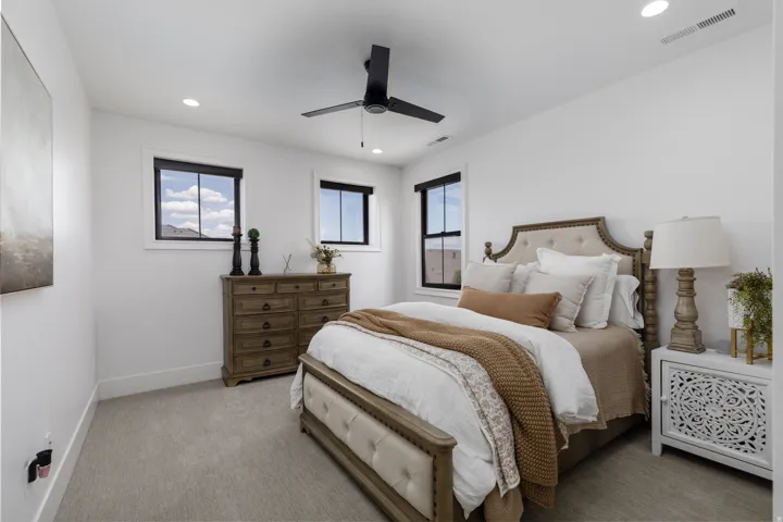 Recessed lighting, ceiling fan, carpeting, and multiple windows with dark trim