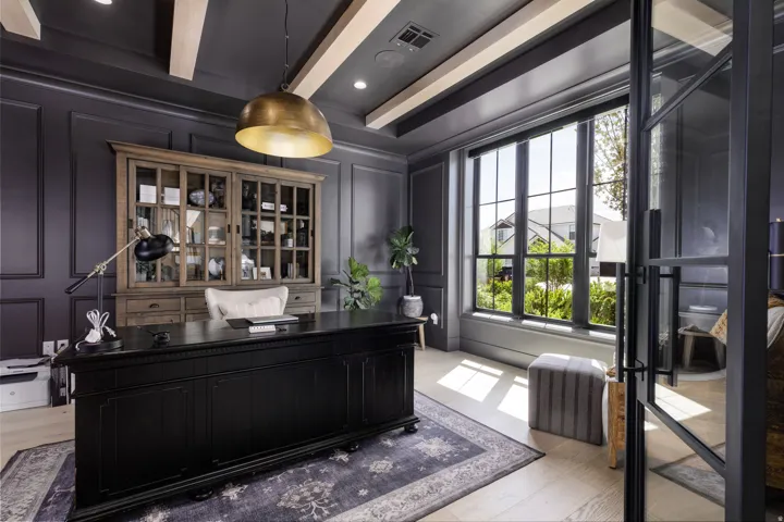 Coffered ceiling with wood beams, panel molding accent walls, large multi-pane window, light wood-finish flooring, and glass-paneled entry door
