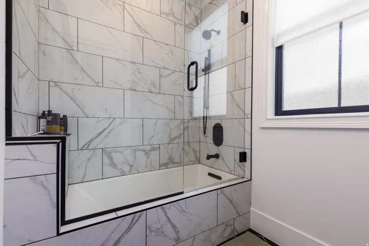 Bathtub with clear glass enclosure and matte black hardware