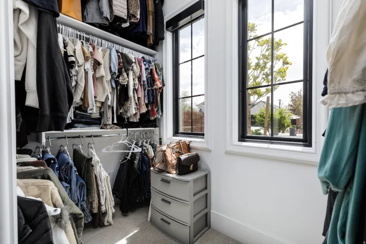 Built-in closet organization system with multiple hanging rods and shelving