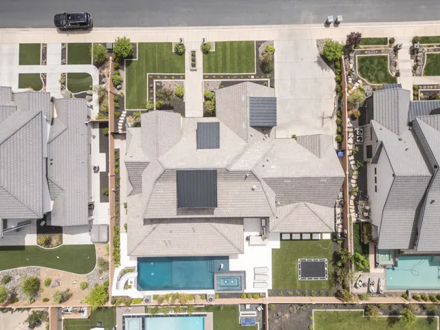 Expansive property featuring a tiled roof, integrated solar panels, a private swimming pool, and an in-ground spa