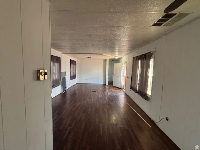 Expansive interior space featuring wood-finish flooring and white paneled walls