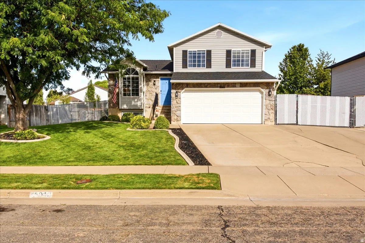 Two-story residence featuring a stone and siding exterior, an attached two-car garage, and a concrete driveway