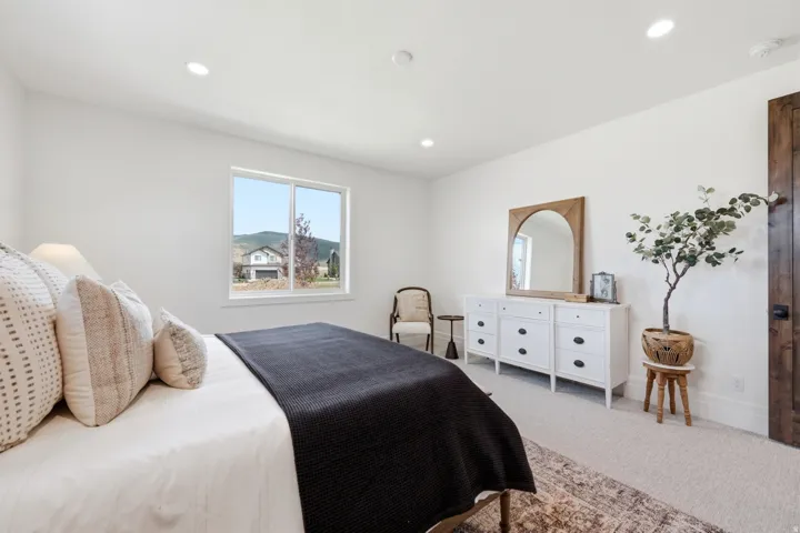 Recessed lighting, wood-finish interior door, white walls, and a window with a mountain backdrop