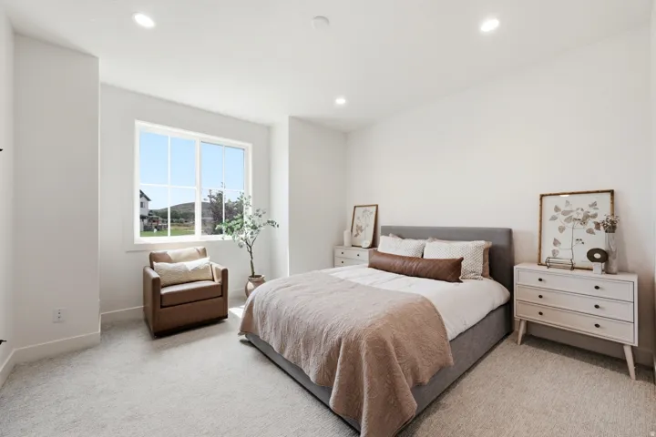 Recessed lighting, large window with multi-pane design, neutral wall color, and light-colored carpet