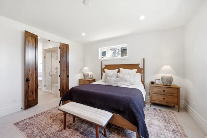 Recessed lighting illuminates the room with light wood-finish flooring