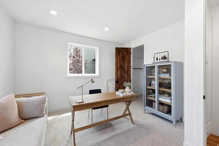 Recessed lighting, wood-finish door, white walls, window, and carpeted flooring