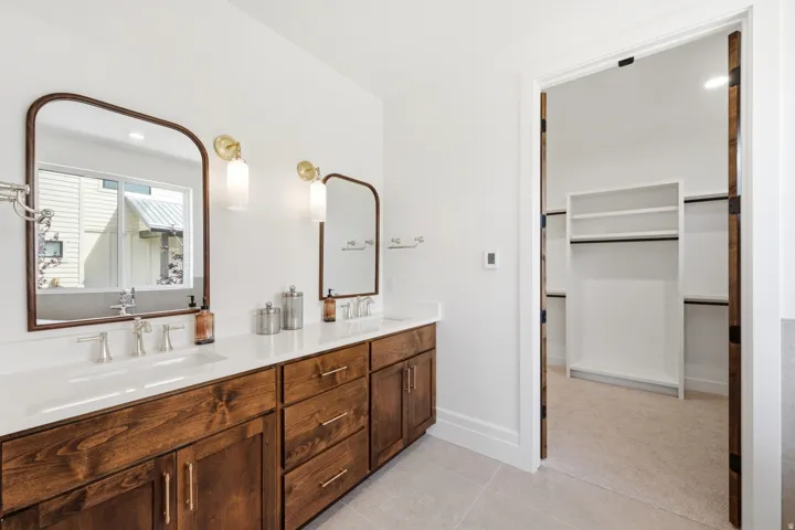 Double vanity with wood-finish cabinetry, white countertop, and dual sinks