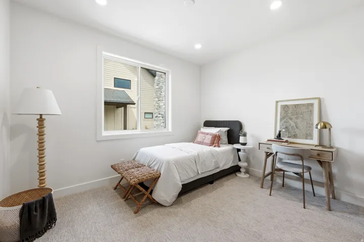 Recessed ceiling lighting, white walls, carpeted flooring, and a large window