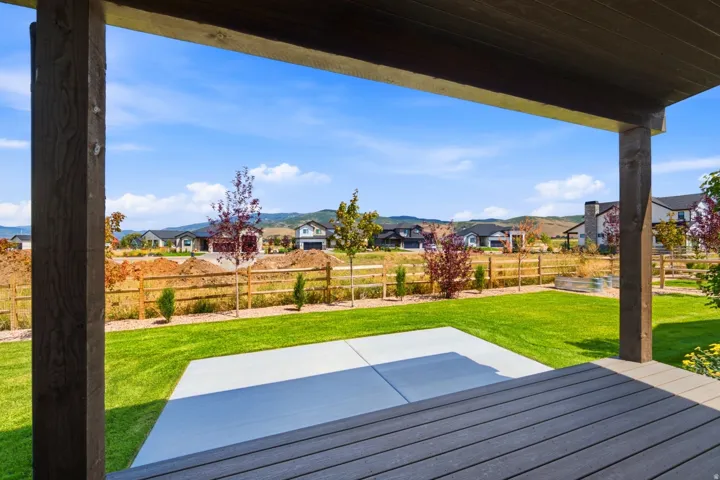 Covered patio with composite decking, concrete slab, and a green lawn