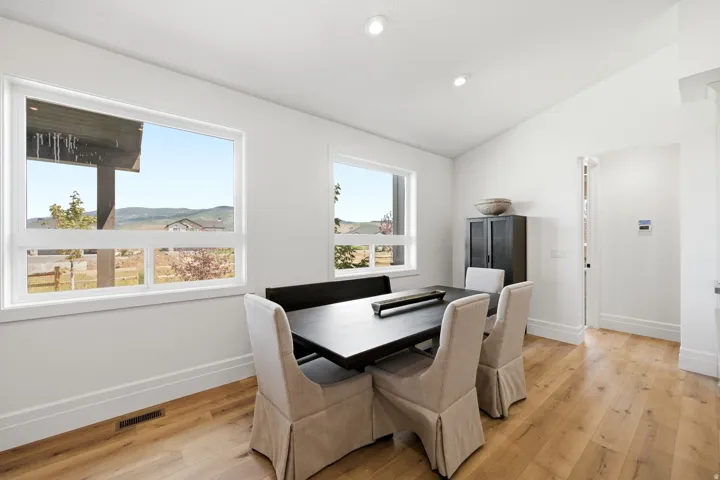 Vaulted ceilings, recessed lighting, wood-finish flooring, white trim, and multiple windows