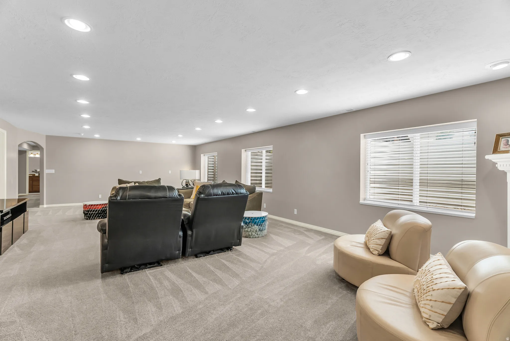 Recessed lighting throughout, neutral-toned walls, and carpeted flooring