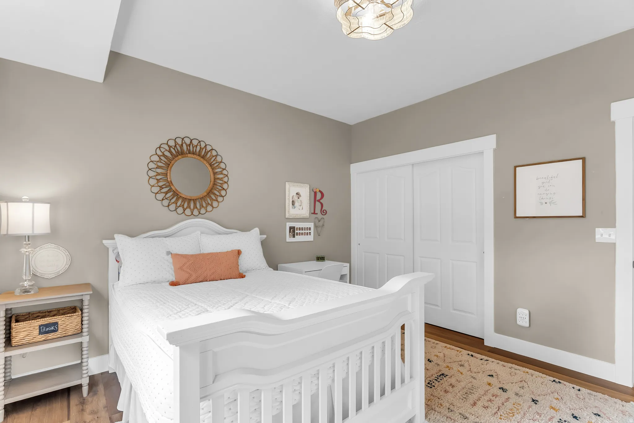 Sloped ceiling, wood-finish flooring, white trim, and sliding closet doors