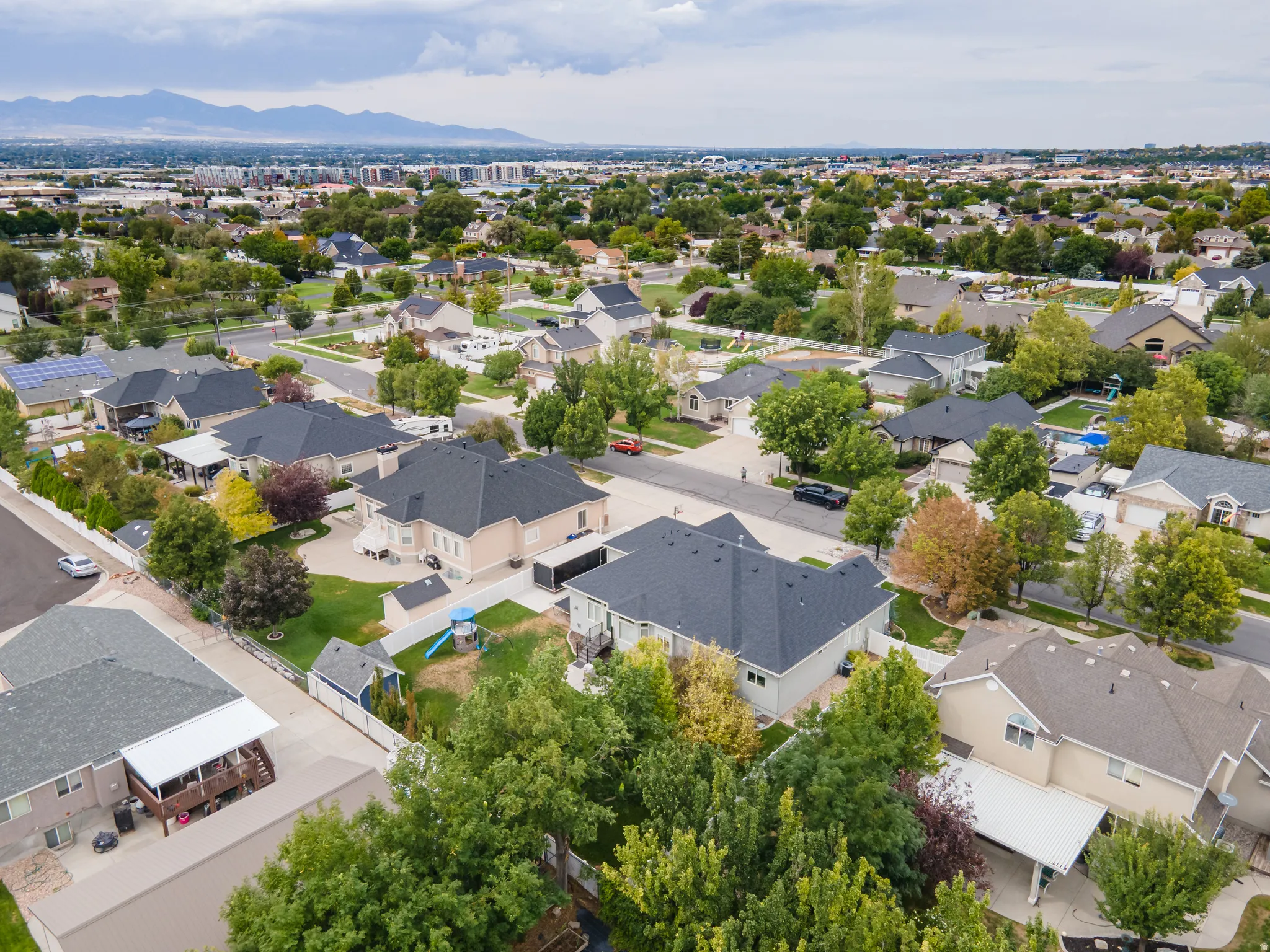 Residential neighborhood with mature trees and mountain scenery