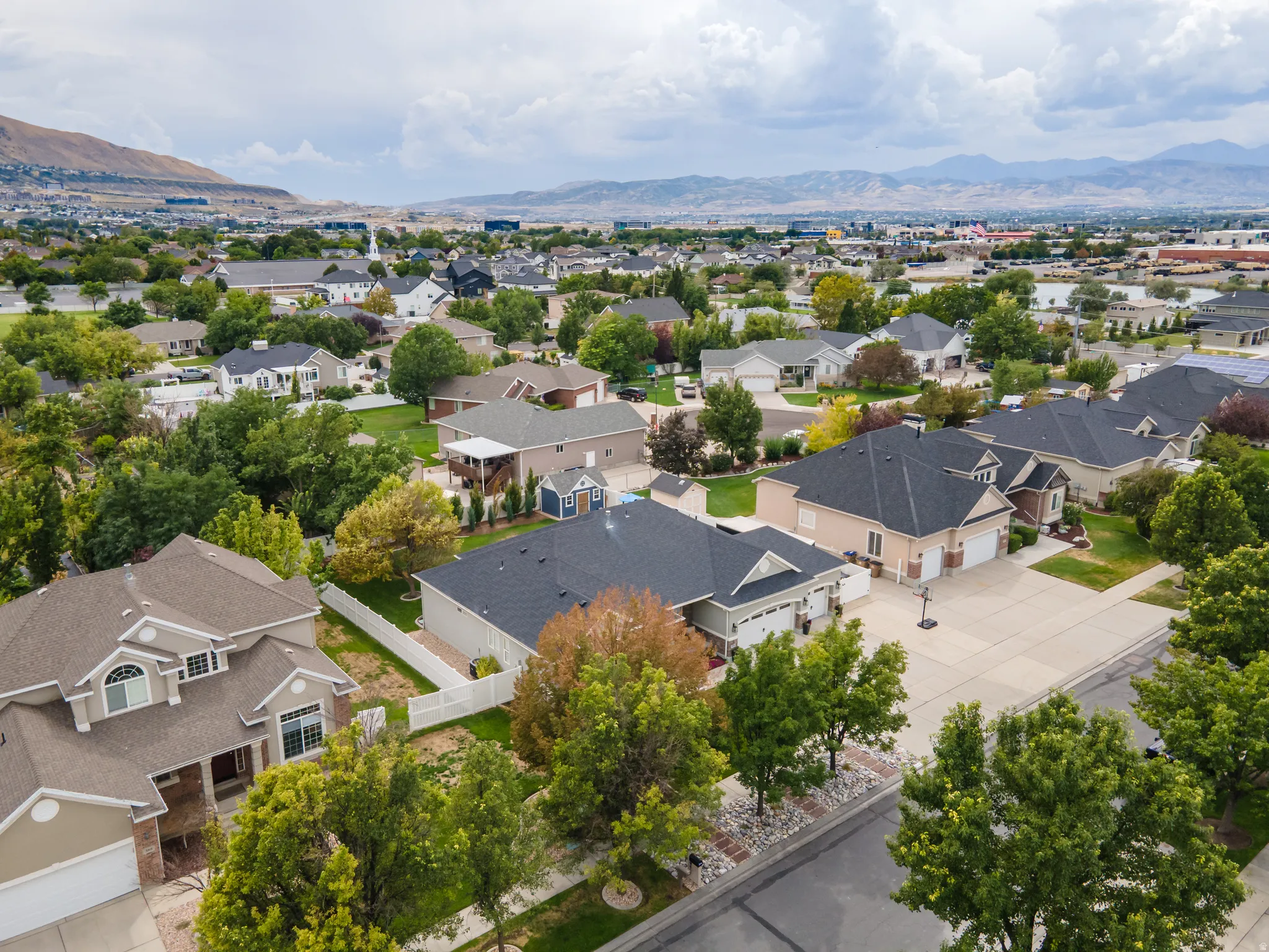 Residential neighborhood with established trees and mountain backdrop