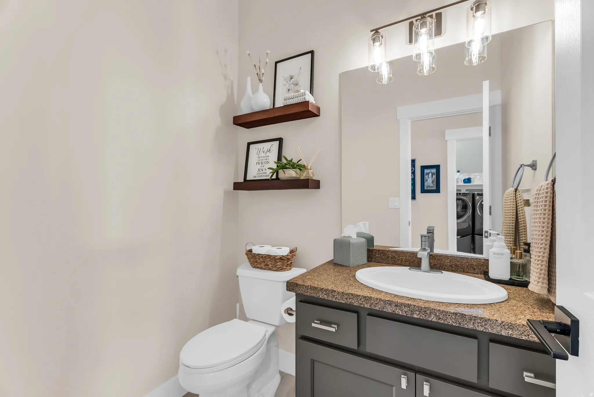 Vanity with a built-in sink, dark gray cabinetry, and a speckled countertop