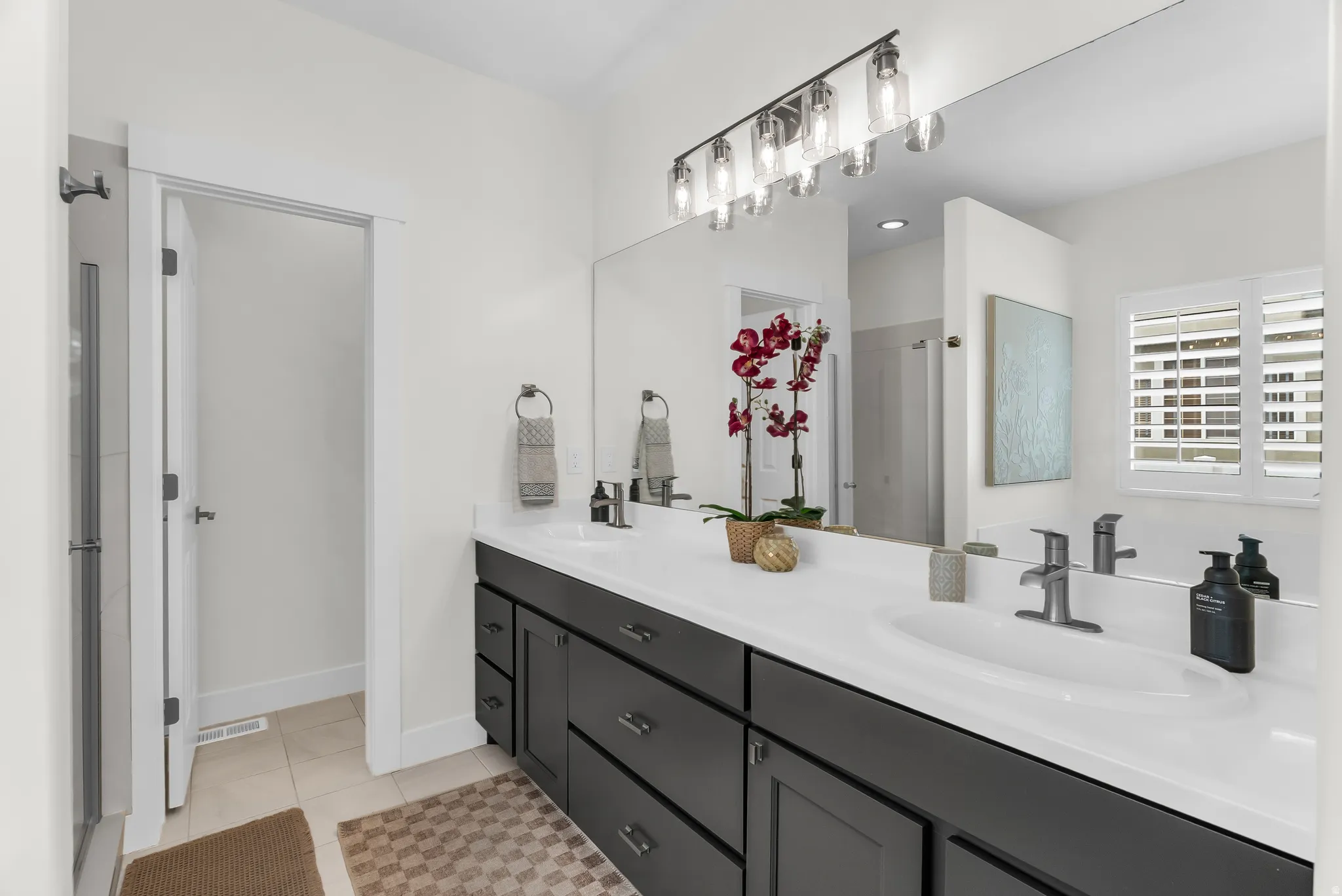Dual vanity with white countertop, dark wood-finish cabinetry, and brushed nickel fixtures