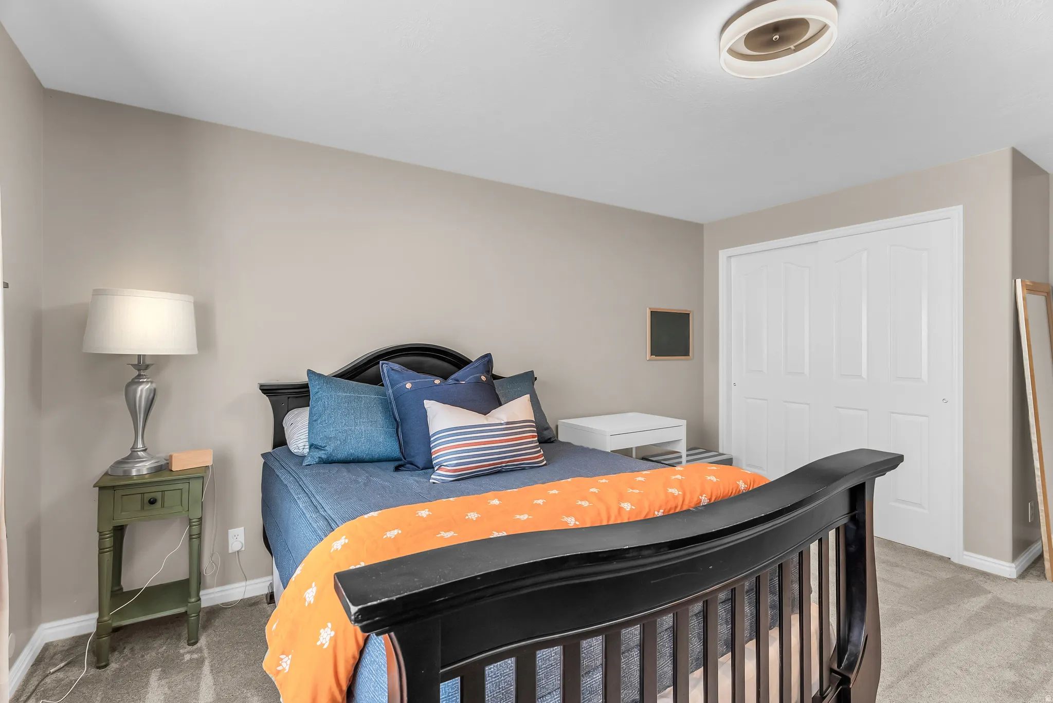 Neutral wall color, carpeted flooring, and a ceiling-mounted light fixture