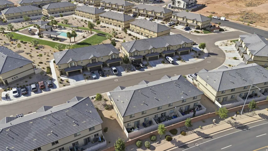Community featuring multiple residential structures, paved roads, and a central amenity area