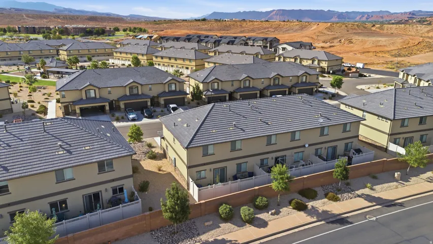 Modern townhome community featuring desert landscaping, paver sidewalks, and a prominent mountain backdrop