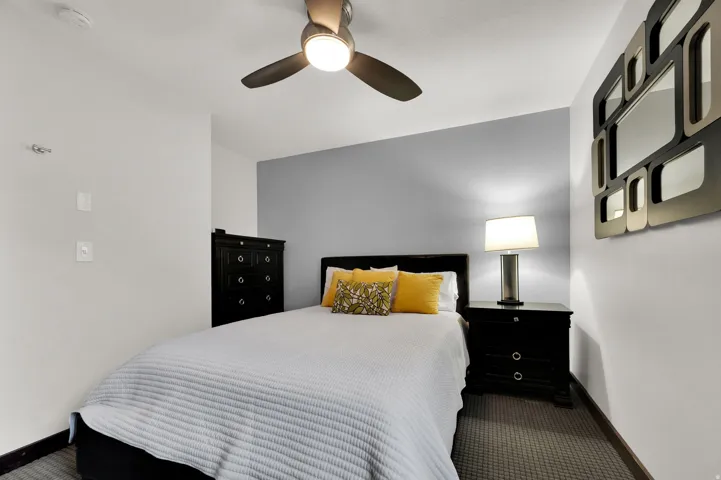 Recessed lighting, ceiling fan with integrated lighting, wall-mounted light fixture, patterned flooring, and a two-tone wall finish