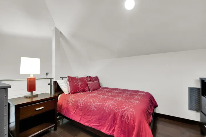 Vaulted ceilings, recessed lighting, and dark wood-finish flooring