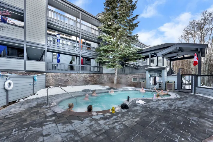 Curved outdoor pool with integrated steps, surrounded by paver flooring
