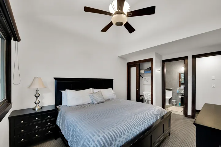 Vaulted ceiling, ceiling fan, dark wood trim, recessed lighting, and carpeted flooring
