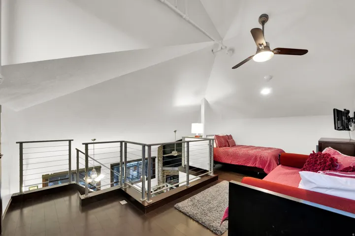 Loft area featuring dark wood-finish flooring, a ceiling fan, recessed lighting, and a cable railing system
