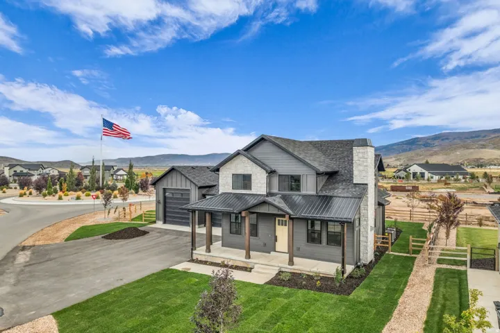 Stone and siding exterior with a dark shingle roof and a covered front porch