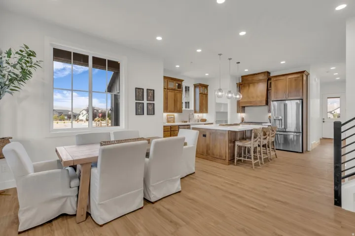 Spacious open-concept living area with wood-finish flooring, recessed lighting, and a large multi-pane window