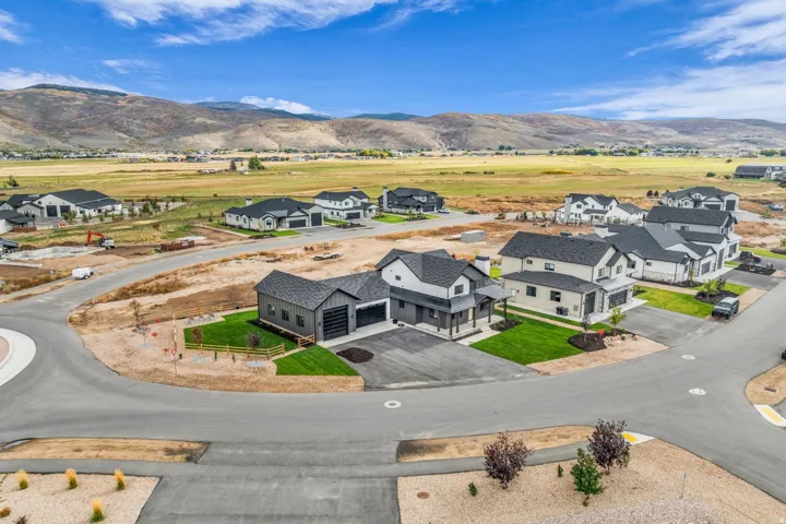 Newly constructed residence featuring a contemporary exterior, attached two-car garage, and a manicured lawn