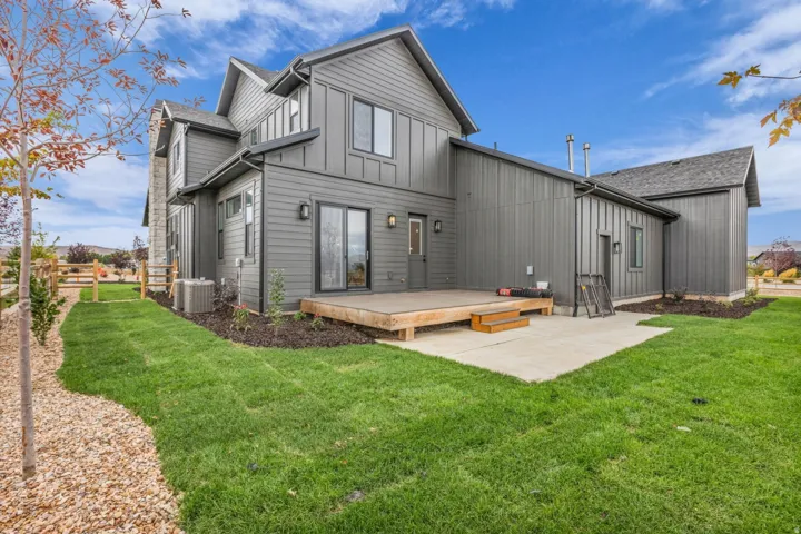 Contemporary exterior with board and batten siding, wood deck, concrete patio, and a fenced perimeter