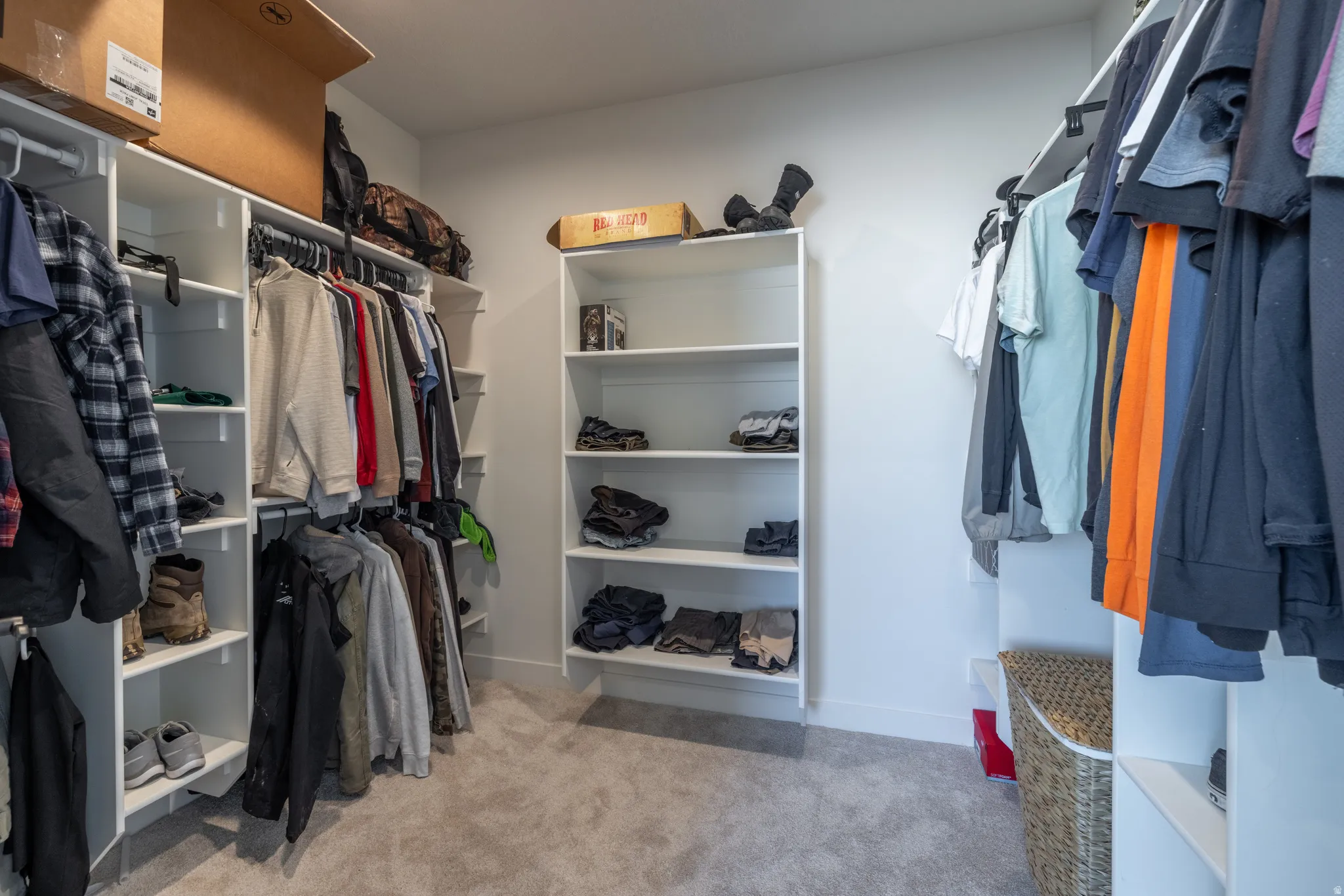 Integrated custom shelving system with multiple hanging rods, built-in open shelving, and plush carpet flooring