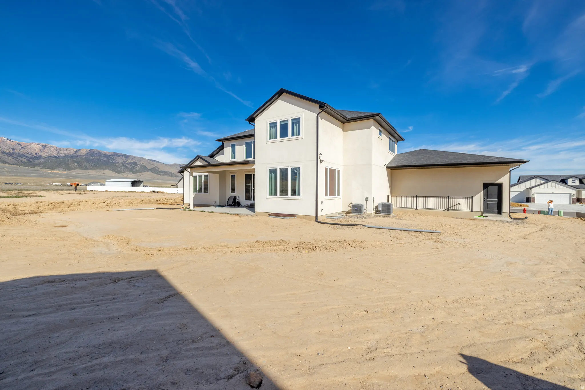 Cream stucco exterior with dark trim and a covered patio