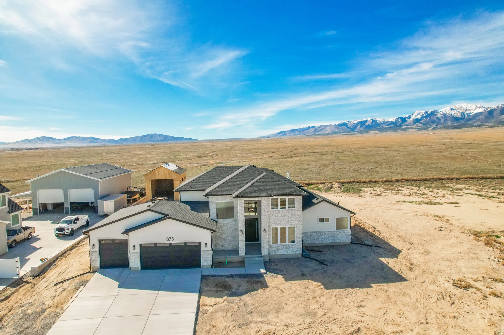 Contemporary exterior with a stone facade, a multi-car garage, and a concrete driveway