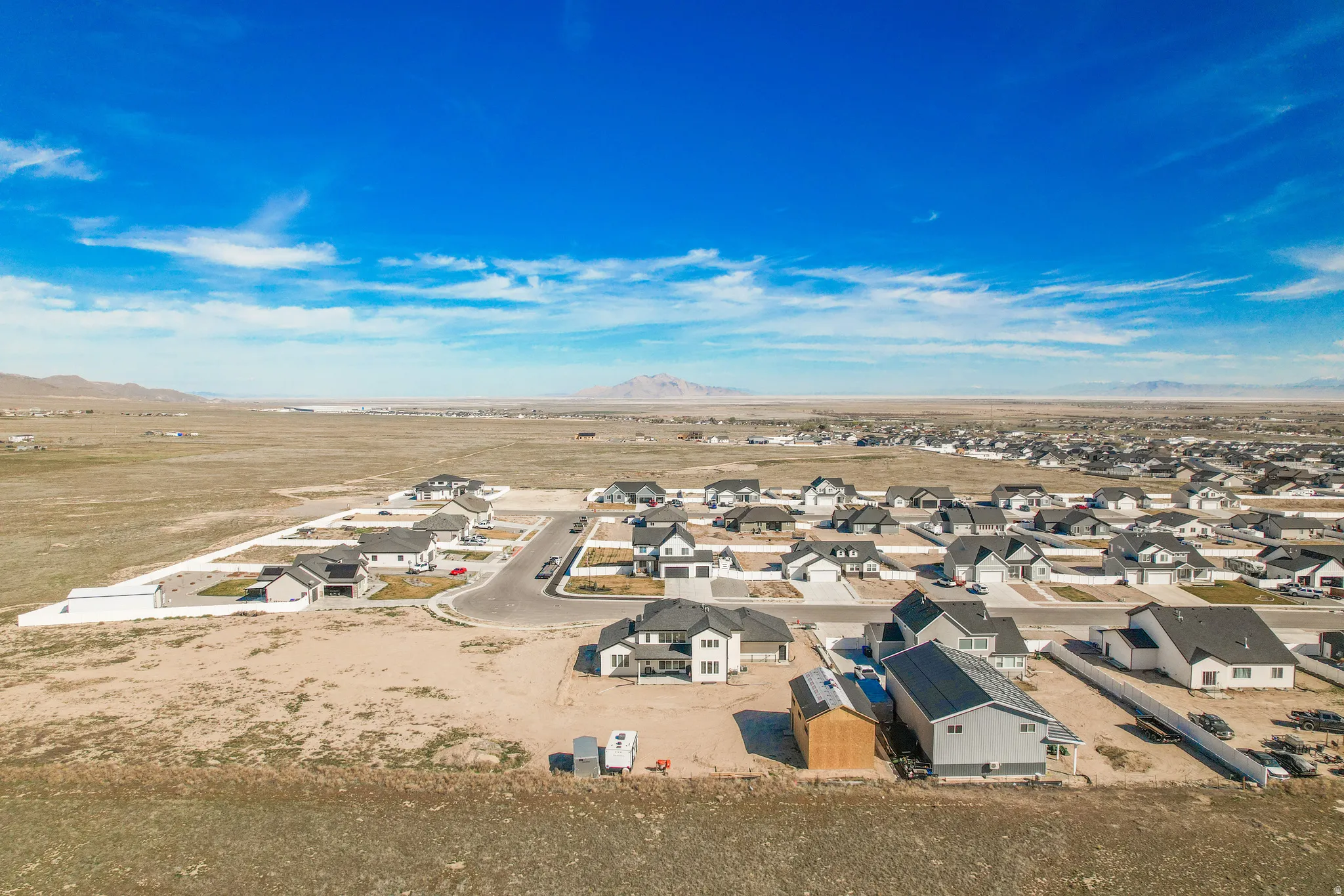 Newly constructed residential community with paved streets and surrounding desert landscape