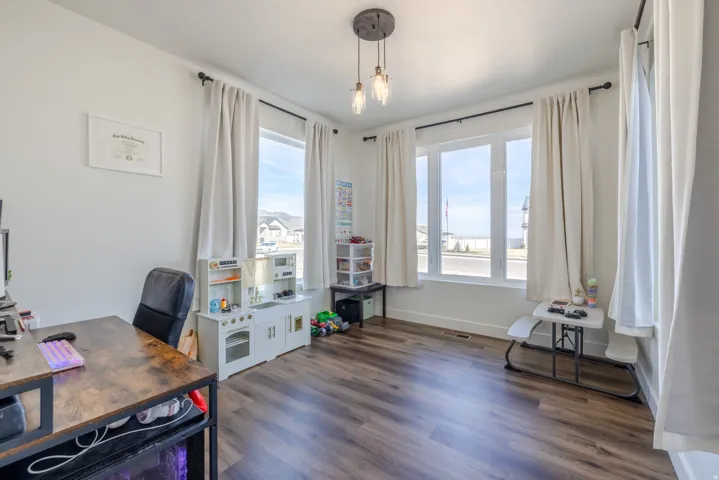 Recessed lighting, wood-finish flooring, and multiple windows with white trim