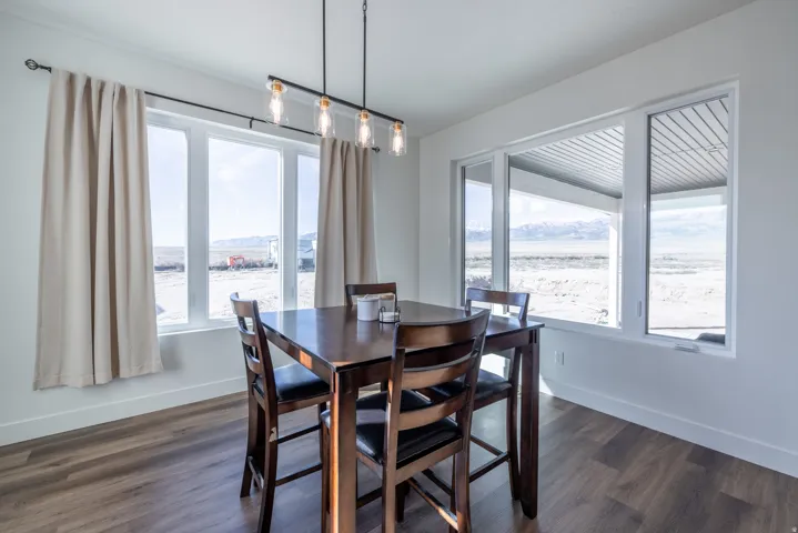 Wood-finish flooring, white walls, and a multi-pane window with a mountain backdrop